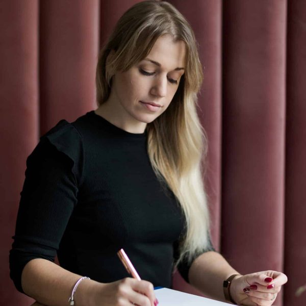 Justyna Kućmierz architektka wnętrz notująca coś na kartce